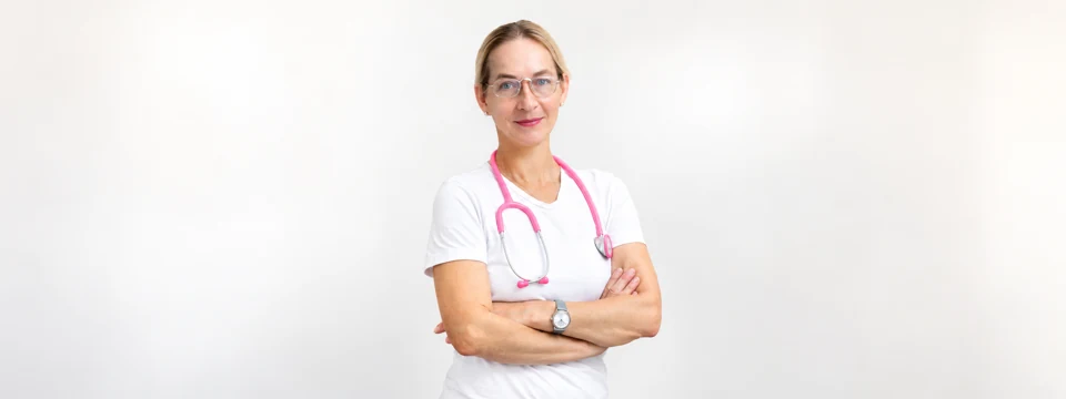 Dr. med. univ. Brigitta Julia Schmidt mit pinkem Stethoskop vor hellem Hintergrund